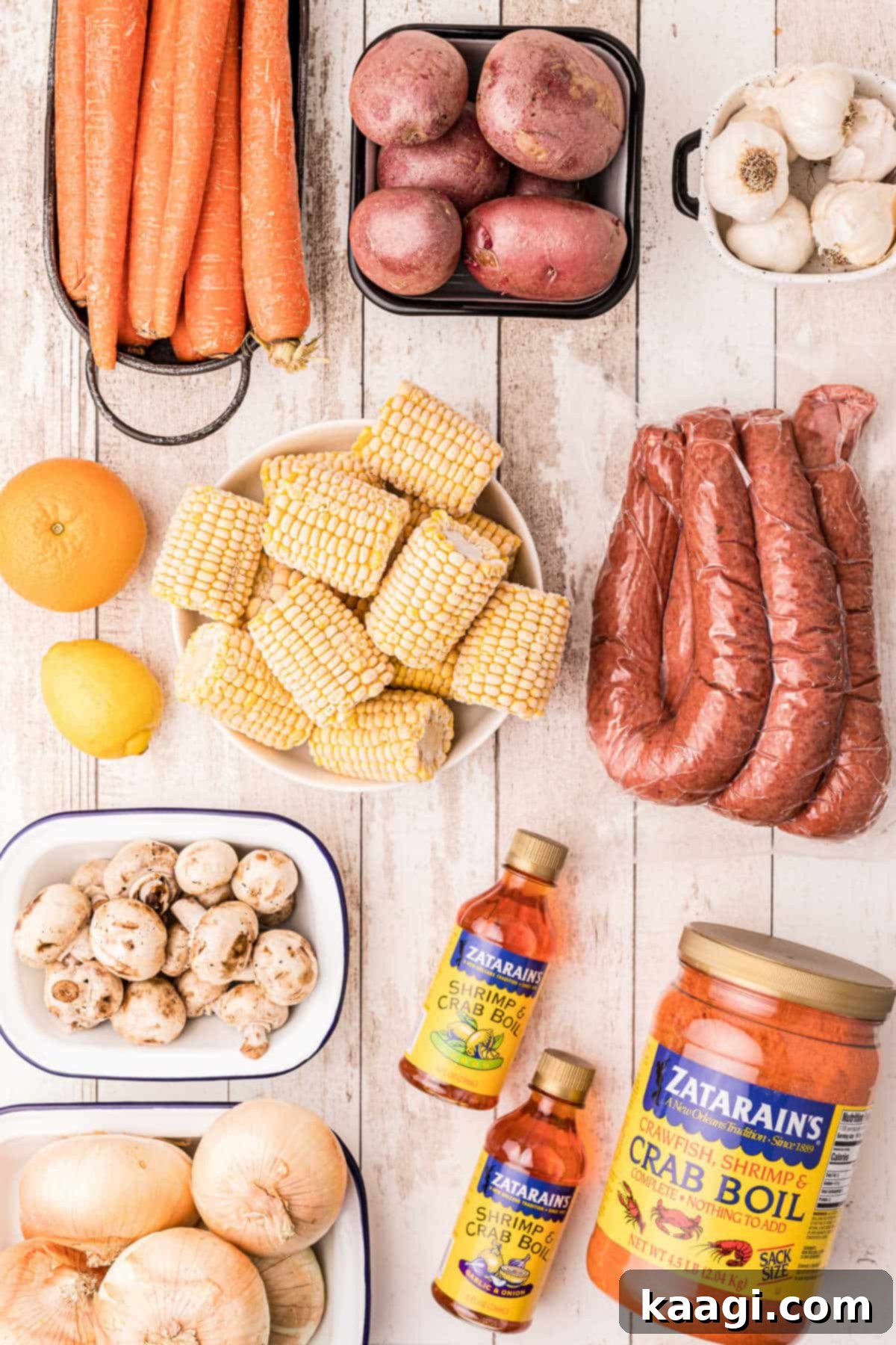 A selection of fresh vegetables and seasonings laid out, ready for a crab boil.