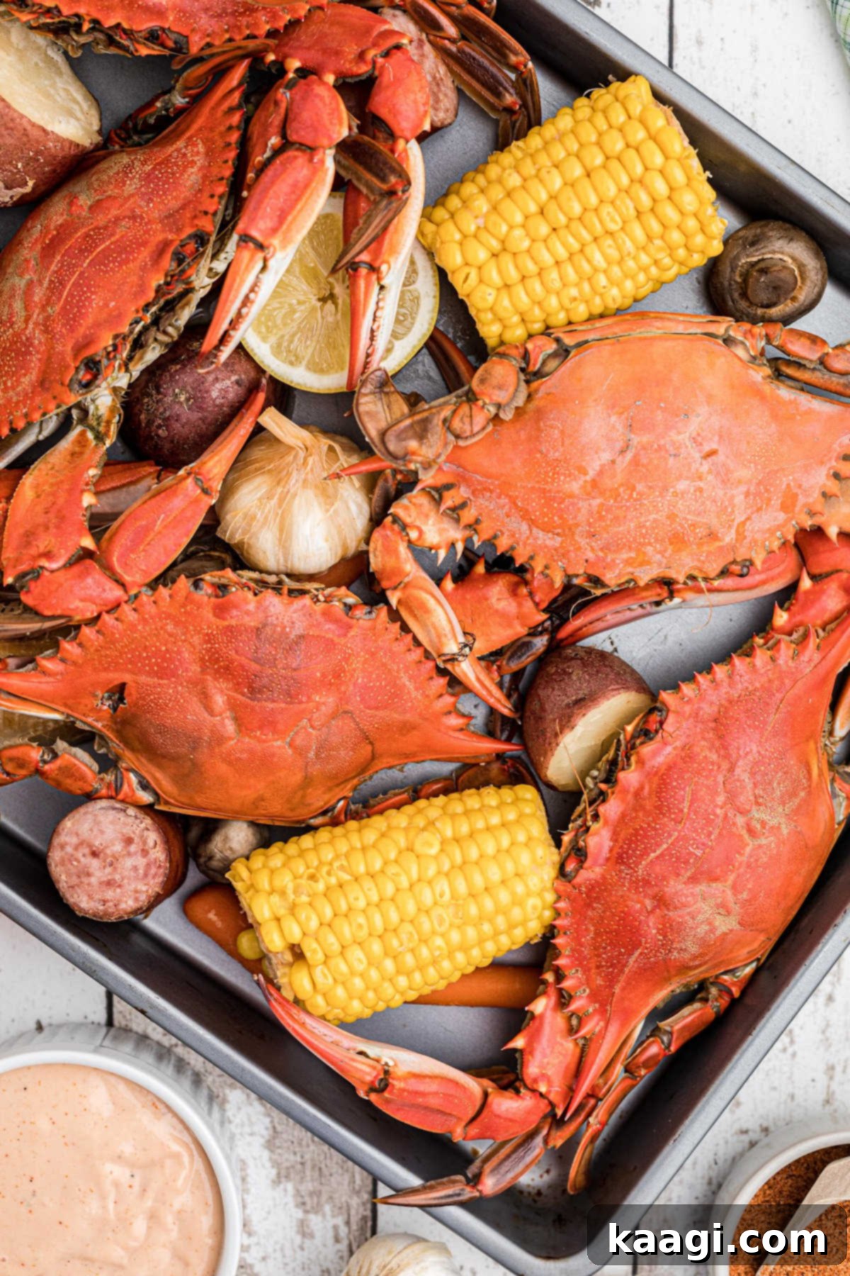 A tray full of vibrant red crabs and colorful vegetables, fresh from a Louisiana crab boil, ready to be enjoyed.