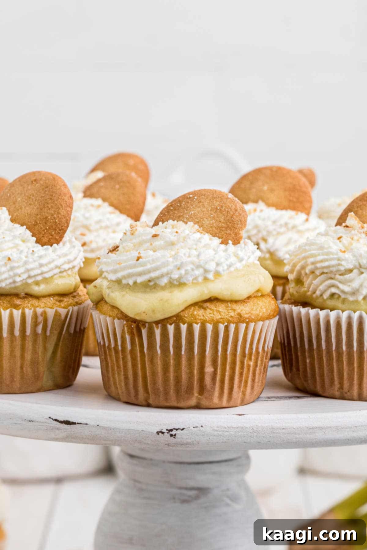 Luscious Banana Pudding Cupcakes 2 a cake stand filled with banana pudding cupcakes that have nilla wafers on top