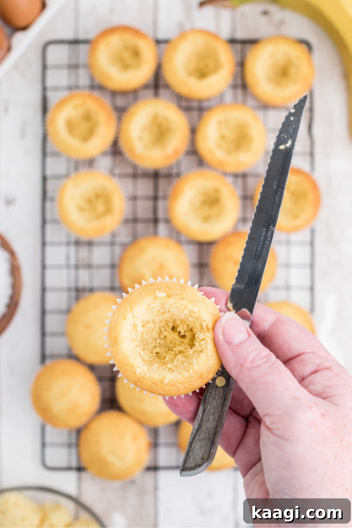 Luscious Banana Pudding Cupcakes 9 Baked cakes with a whole cut into the center of them.
