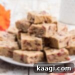 A plate full of maple bacon fudge, garnished with a maple leaf and bacon slices.