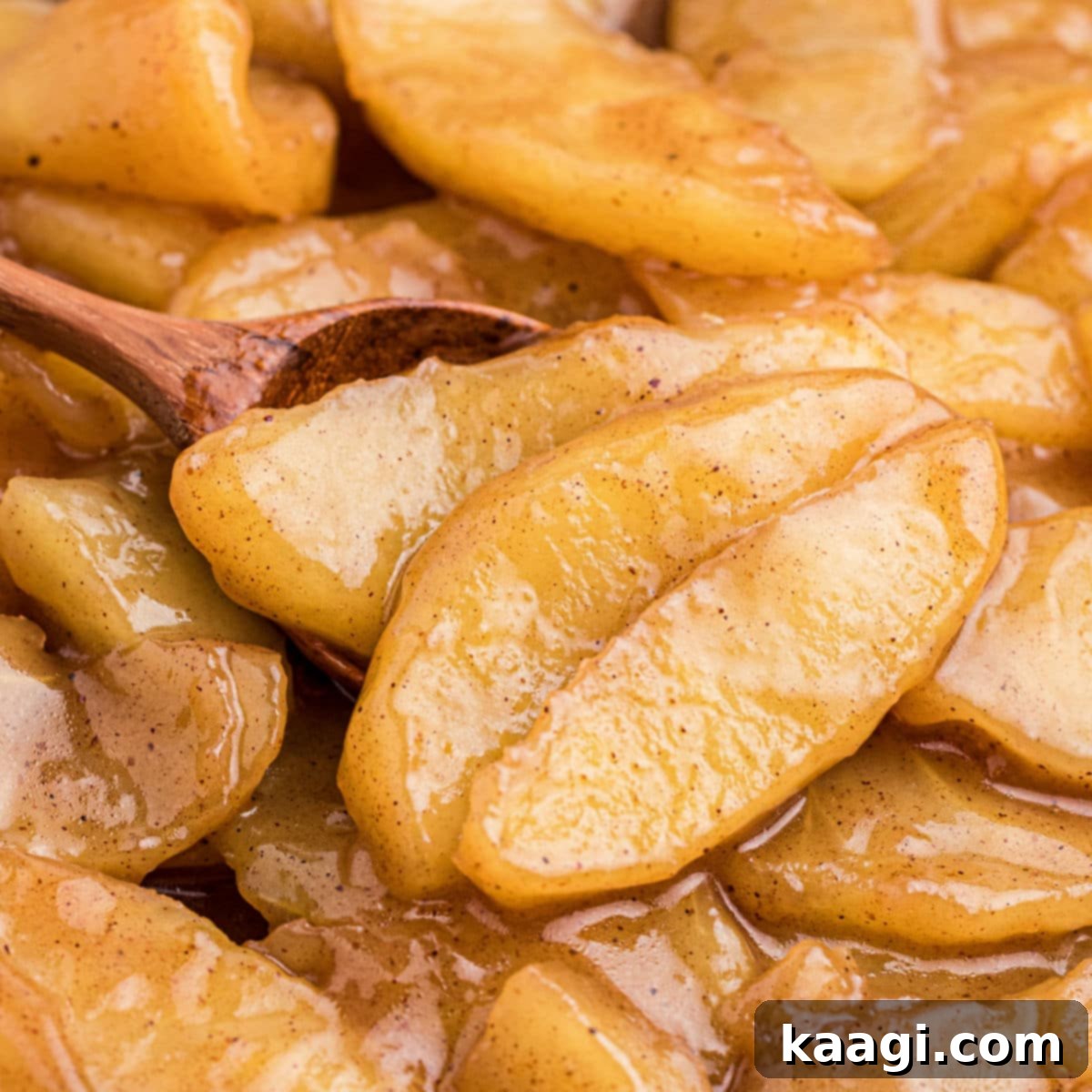 Close up of fried apples with a wooden spoon.