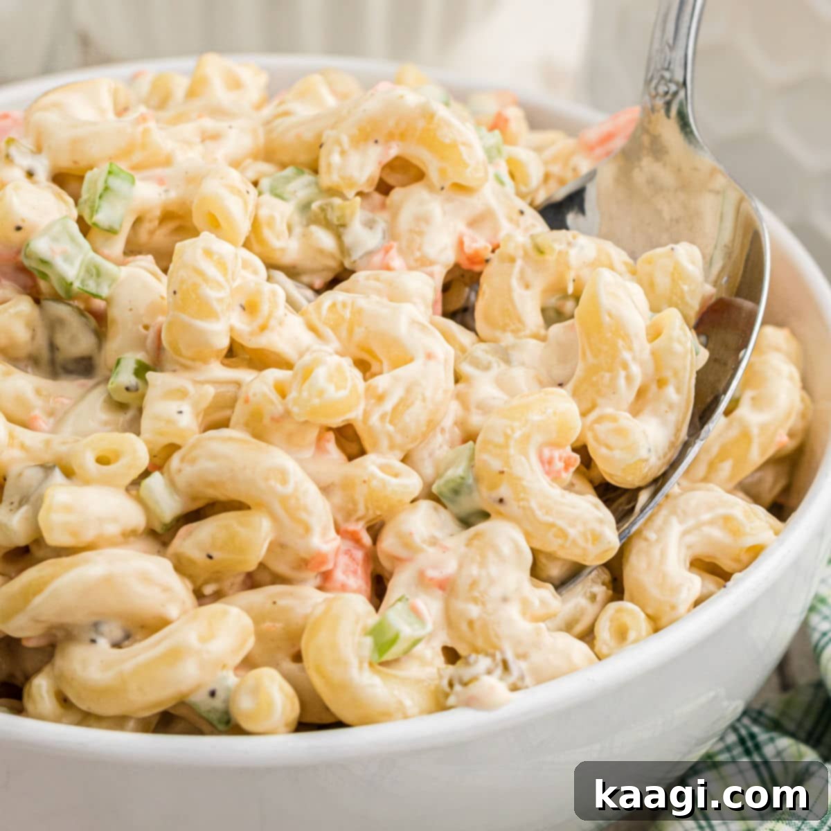 Close up of a bowl of KFC Macaroni Salad with a spoon digging in.