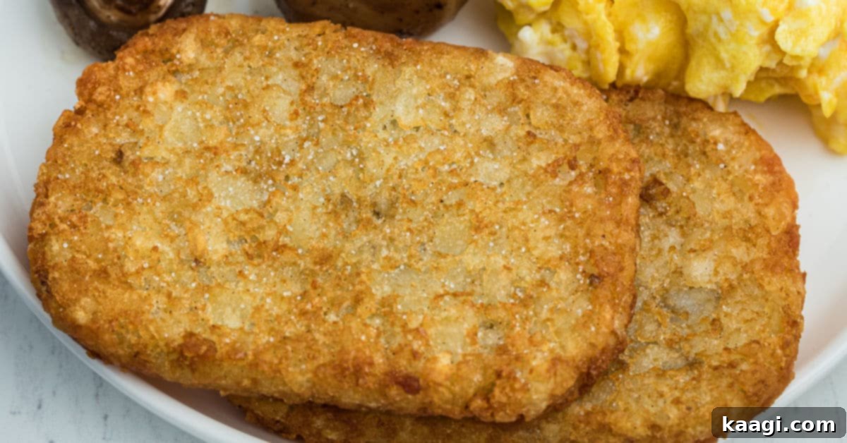 a close up picture of 2 hash browns with scrambled eggs and mushrooms behind