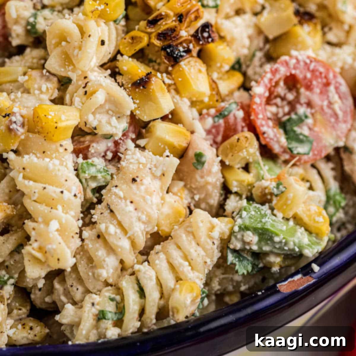 Very close up shot of a bowl of Elotes Pasta salad, cropped square.