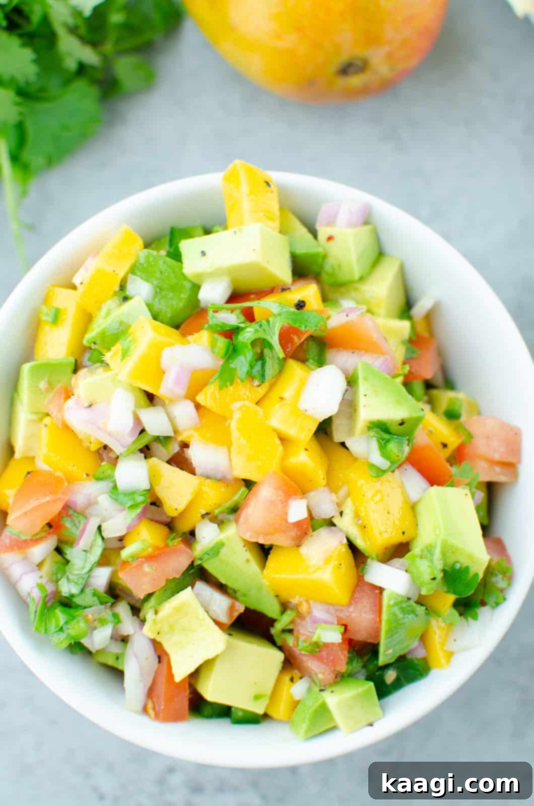 a bowl full of mango avocado and other salad items