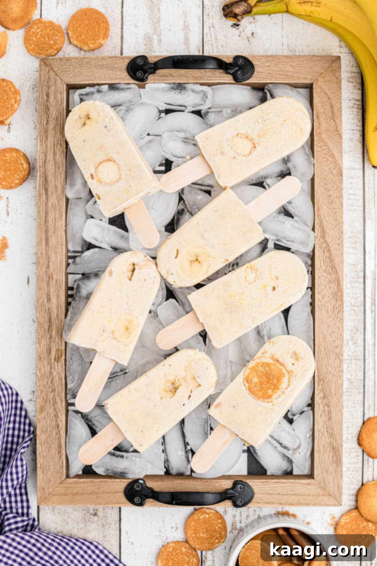 A tray filled with ice, topped with several homemade banana pudding popsicles, ready to be enjoyed.