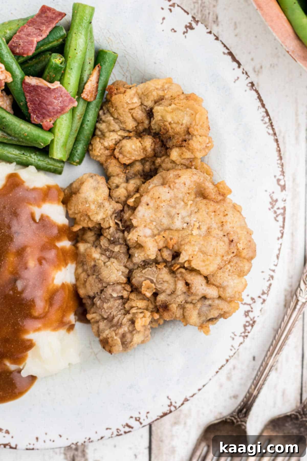 Succulent Pan-Seared Venison Cutlets 2 close up of a fried venison cutlet on a plate with mashed potatoes and gravy