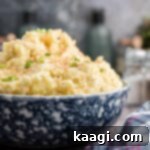 Zesty Cajun Potato Salad 15 A close-up image of a large bowl of creamy Cajun potato salad with fresh green onions sprinkled on top