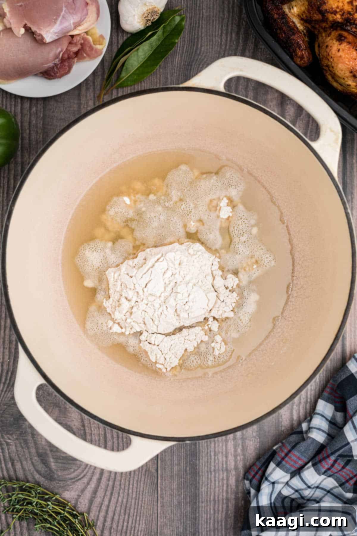 Crafting the Deep Flavor of Dark Roux 5 All-purpose flour being added to hot oil in a pot, the start of a delicious roux.