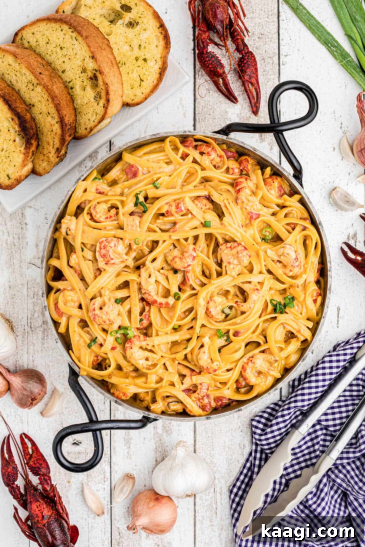 Creamy Cajun Crawfish Fettuccine 14 overhead view of crawfish fettuccine in a skillet with boiled crawfish and garlic and texas toast arranged around