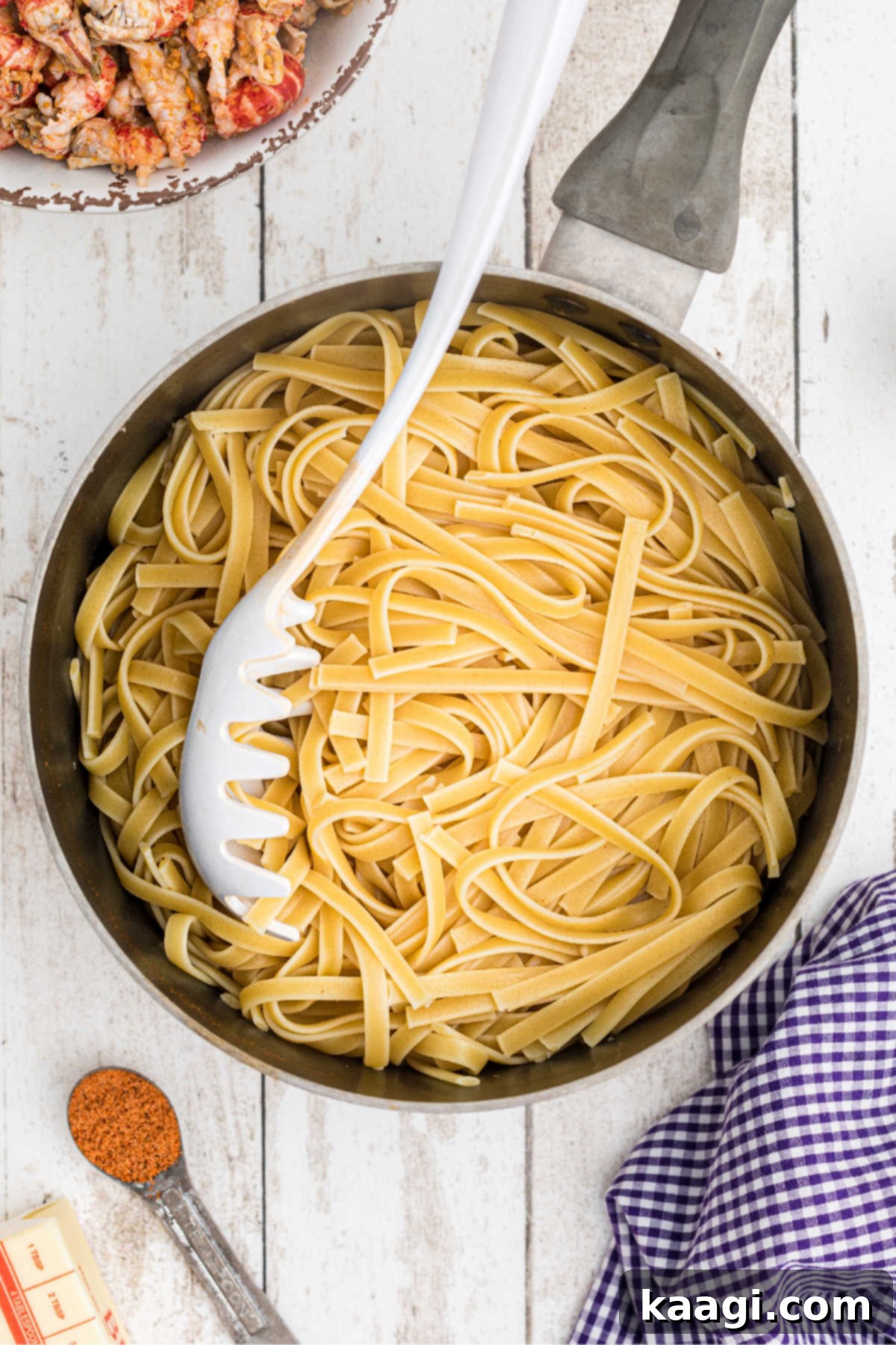 Creamy Cajun Crawfish Fettuccine 5 Cooked Fettuccine in a pot with a pasta spoon.