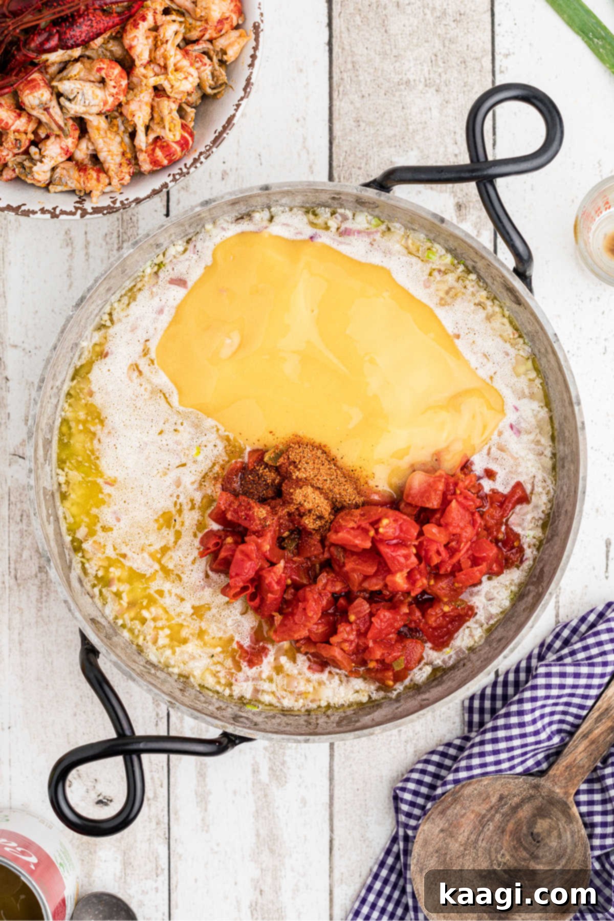 Creamy Cajun Crawfish Fettuccine 8 A skillet with some cheese sauce added with some tomatoes.