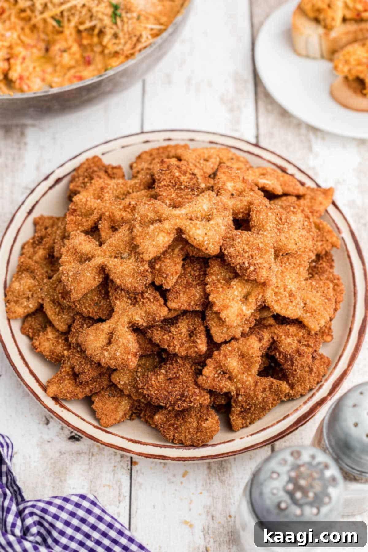 Crispy Farfalle Bites 2 A plate filled with golden brown, crispy fried bowtie pasta, ready to be served as an appetizer.