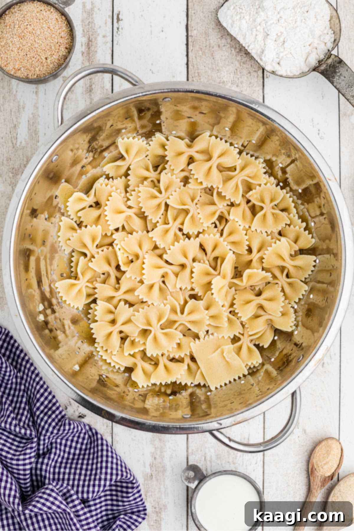 Crispy Farfalle Bites 4 Cooked bowtie pasta in a colander, draining excess water after boiling, ensuring a dry surface for optimal frying.