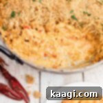 skillet of crawfish dip with breadcrumbs on top, with cream cheese. Crawfish in the corners.