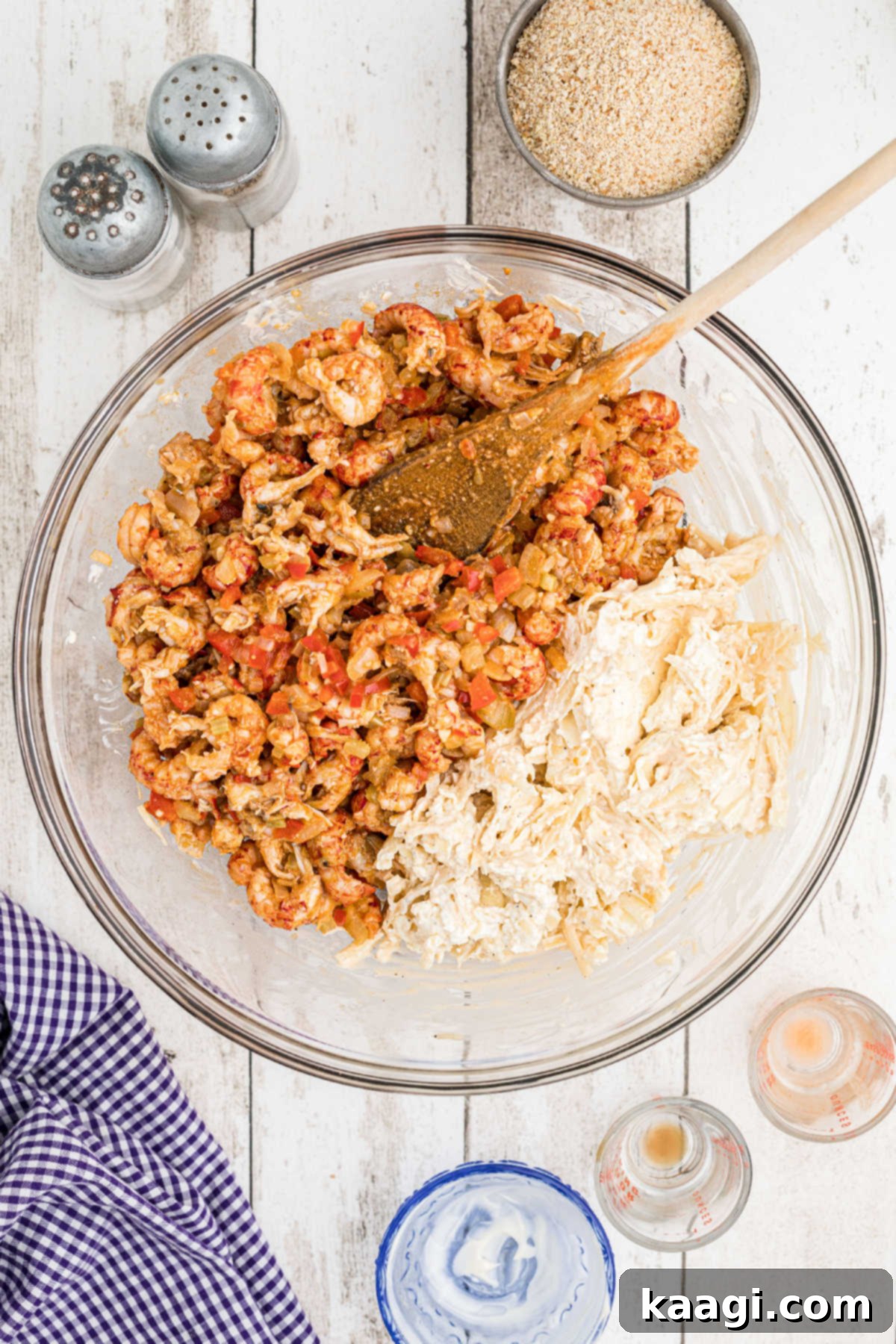A crawfish mixture added to a mixing bowl with a mixture of cheeses.