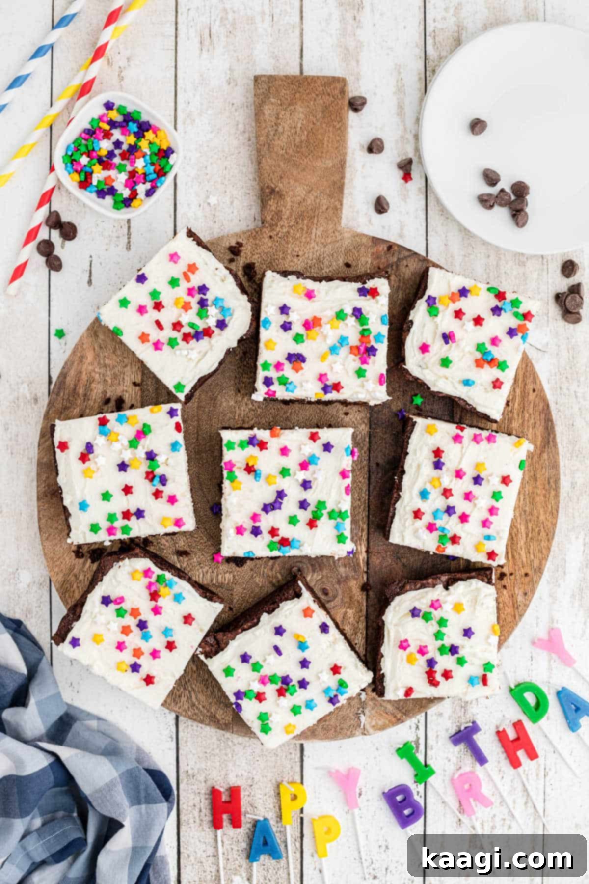 Precisely cut birthday brownies arranged in neat squares on a round wooden chopping board, ready to be served or enjoyed.