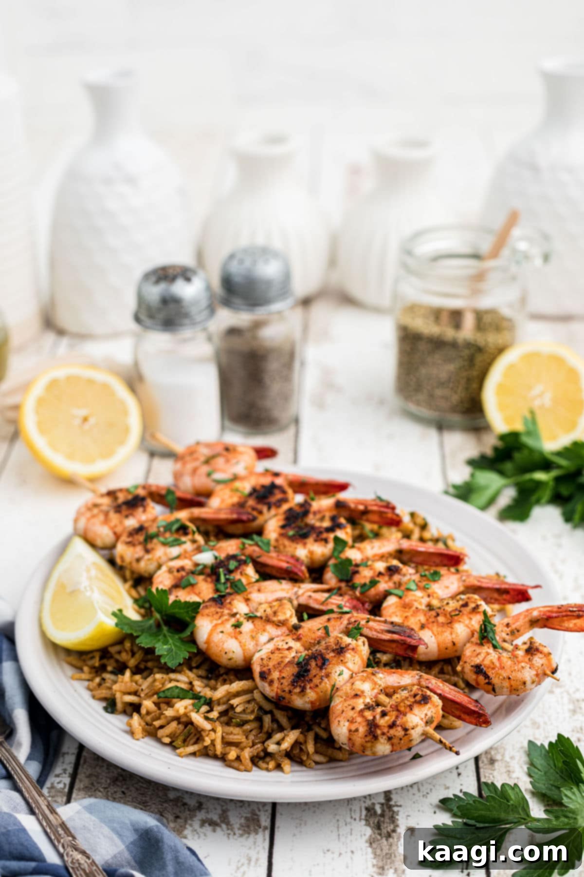 Beautifully arranged Texas Roadhouse grilled shrimp skewers on top of seasoned rice, with fresh lemon slices and parsley garnish in the background.