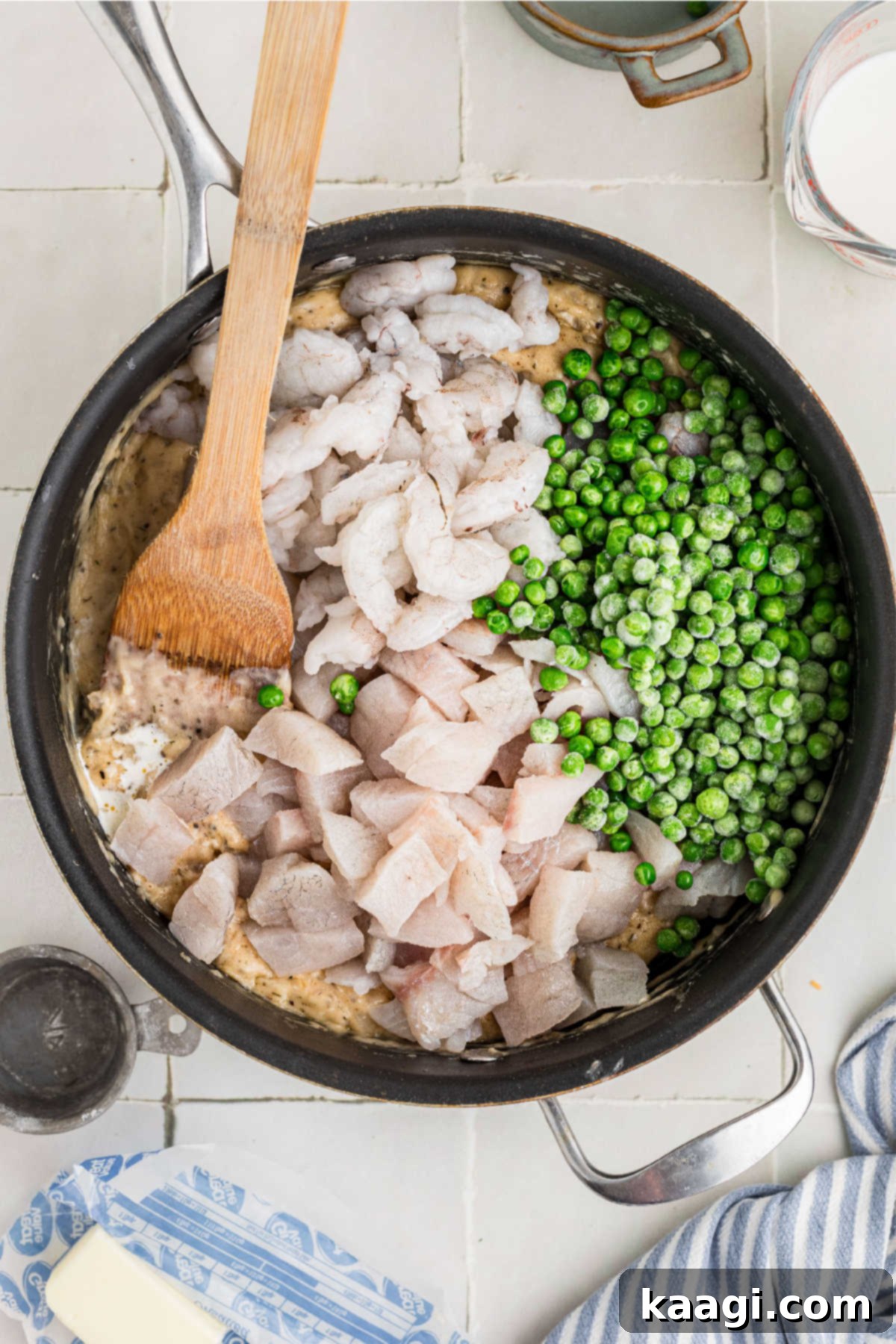 Fish, shrimp and peas added to a skillet.