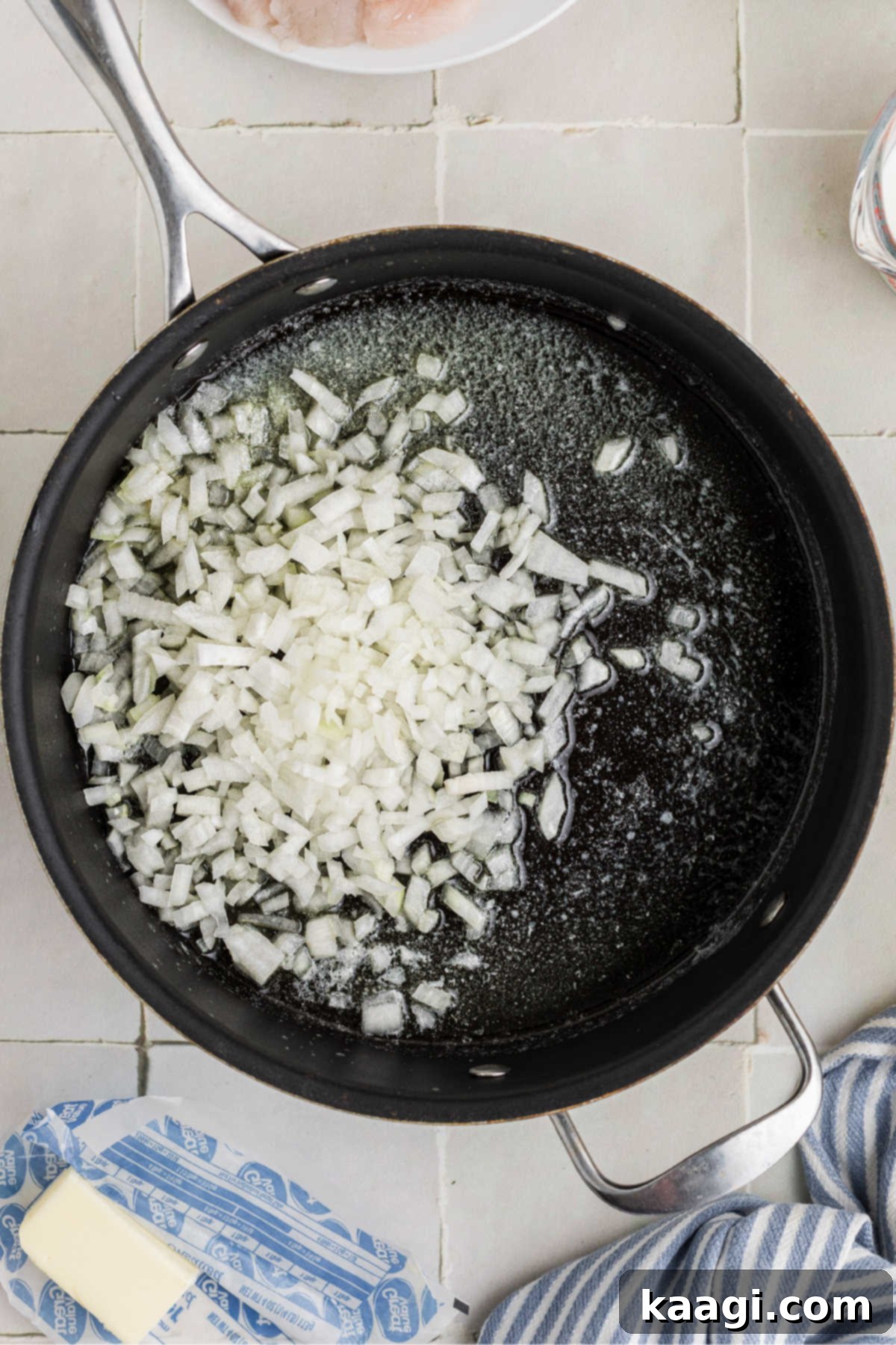 Diced onions cooking in a skillet.