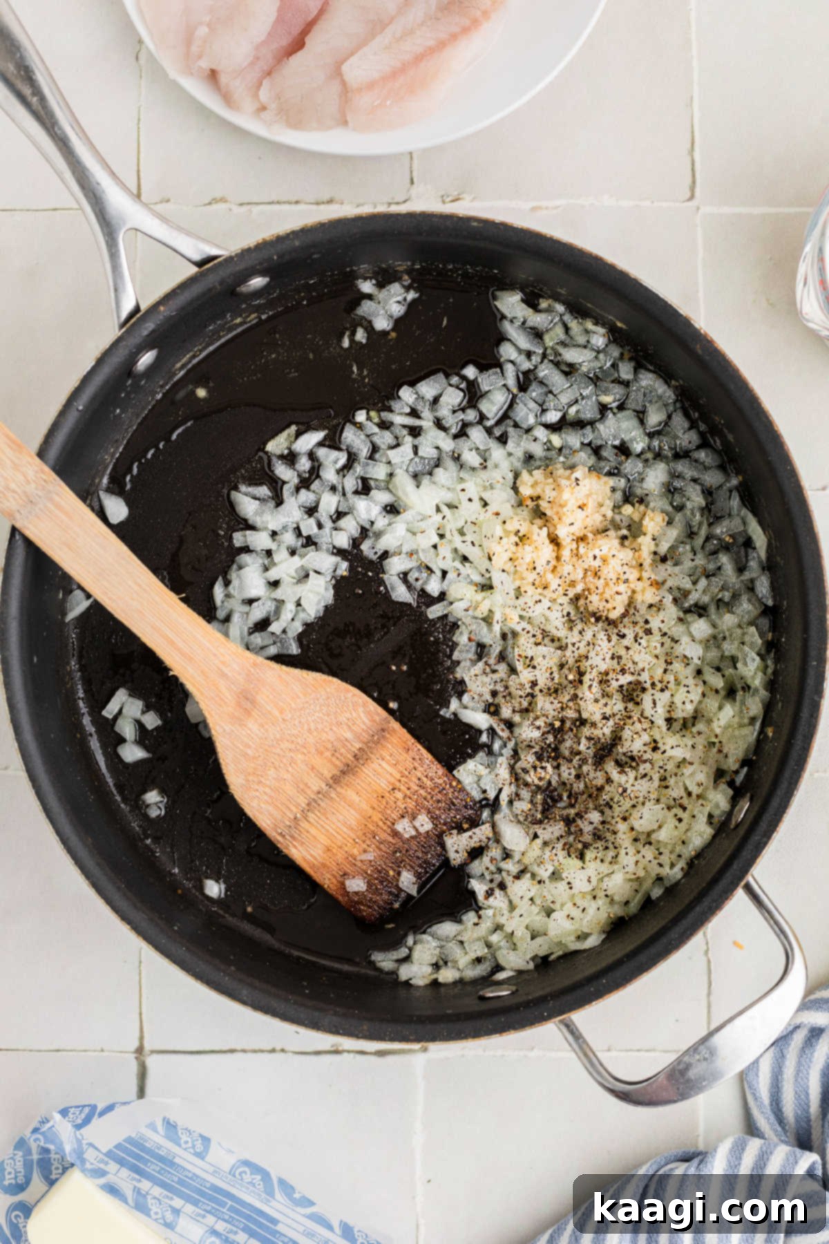 Garlic added to a skillet with onions.