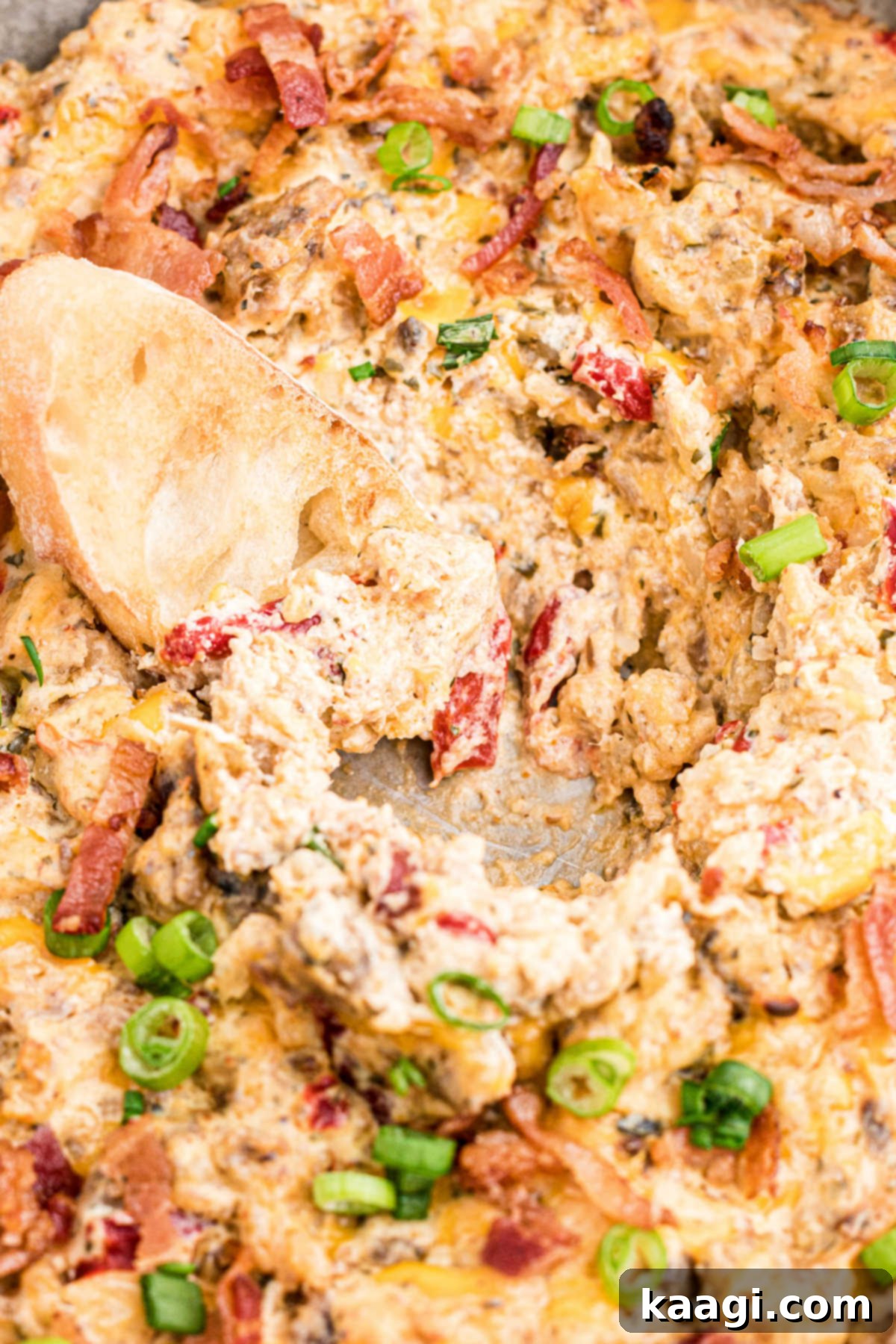 A close-up shot of the creamy boudin dip in a skillet, with a portion already scooped out, highlighting its rich texture.