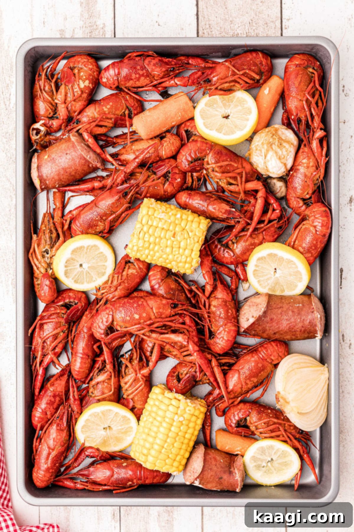 The Ultimate Crawfish Boil 11 A festive platter generously piled with boiled crawfish, corn, and potatoes, ready for a gathering. A small bowl of seafood dip is visible in the foreground.