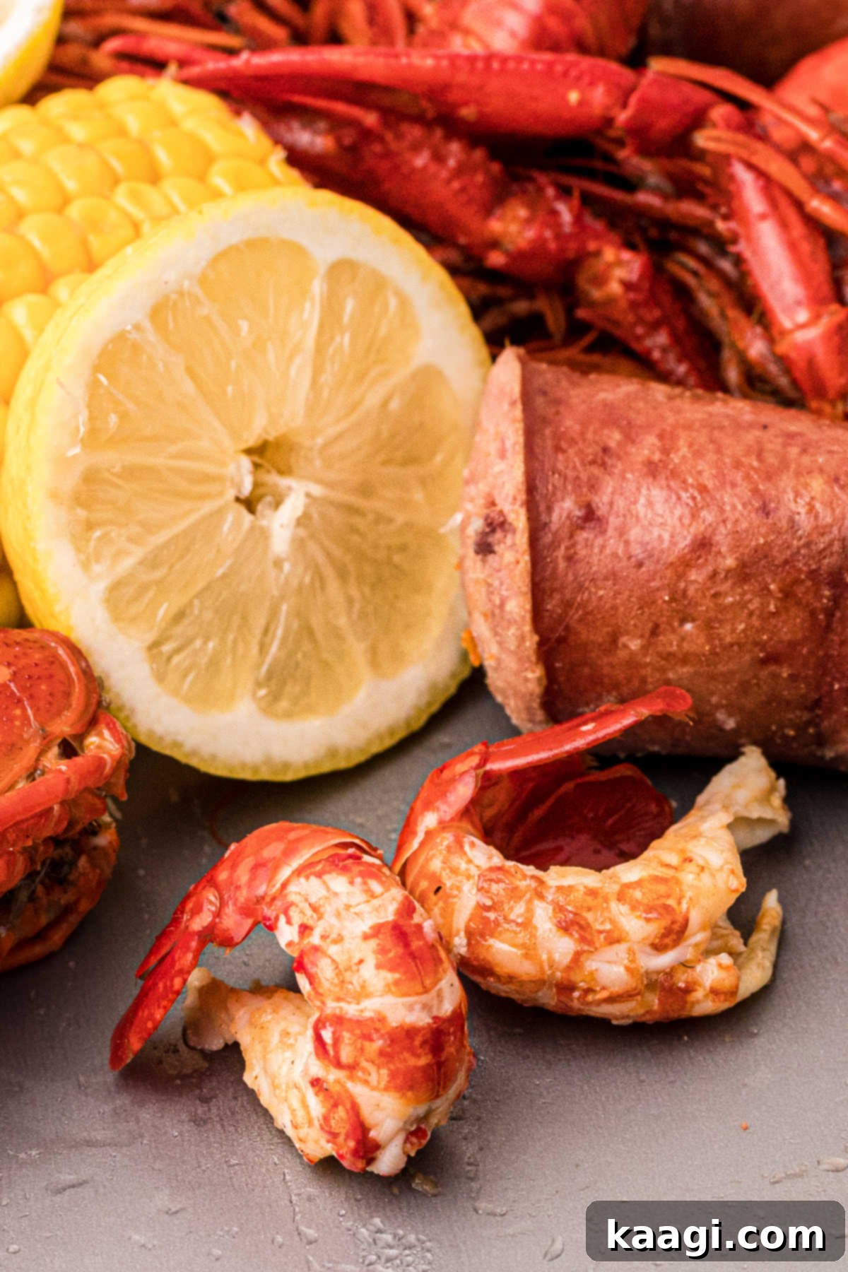 close up of peeled crawfish with sausage and corn in the background