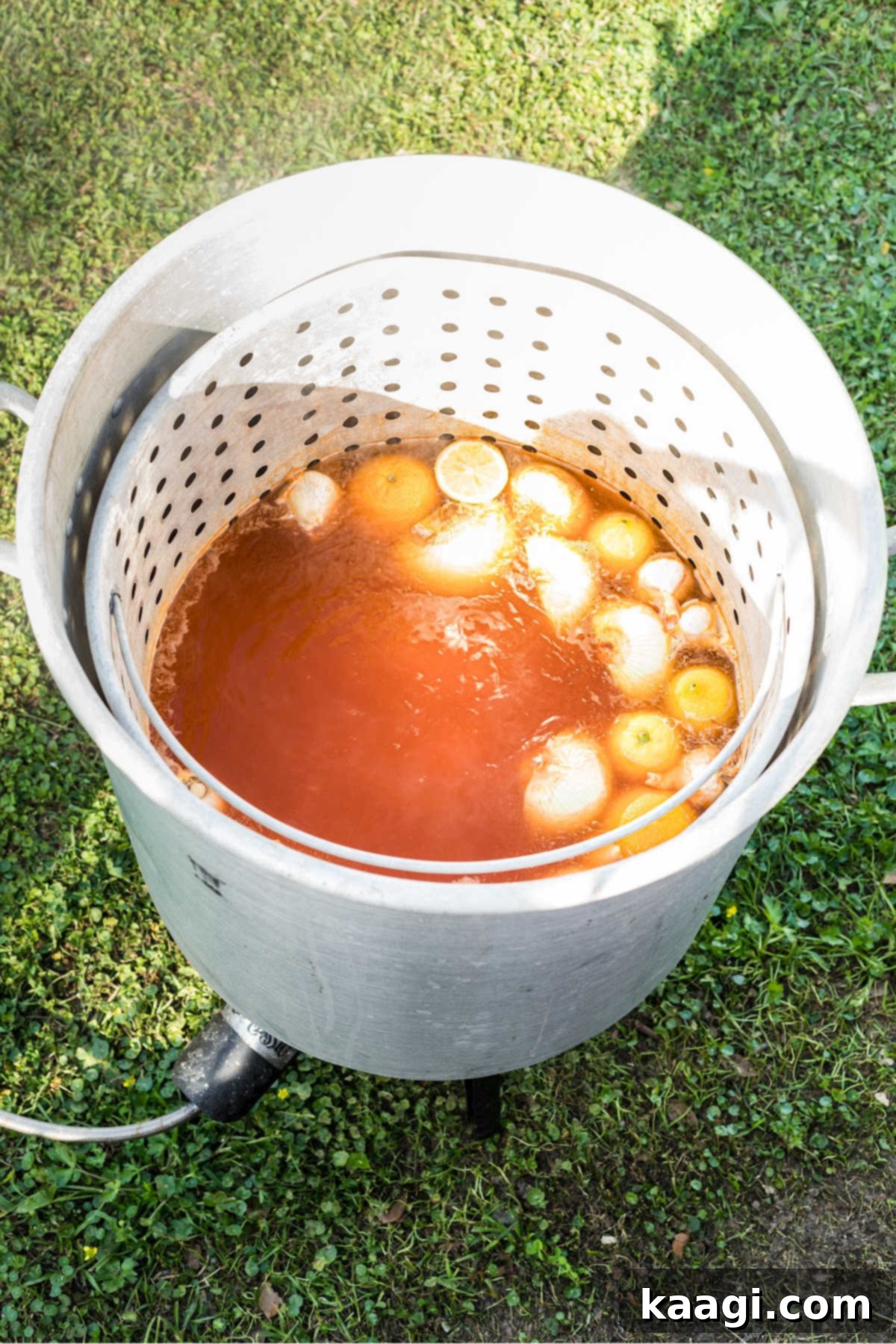 A large seafood boiling pot with seasoned water and vegetables cooking.
