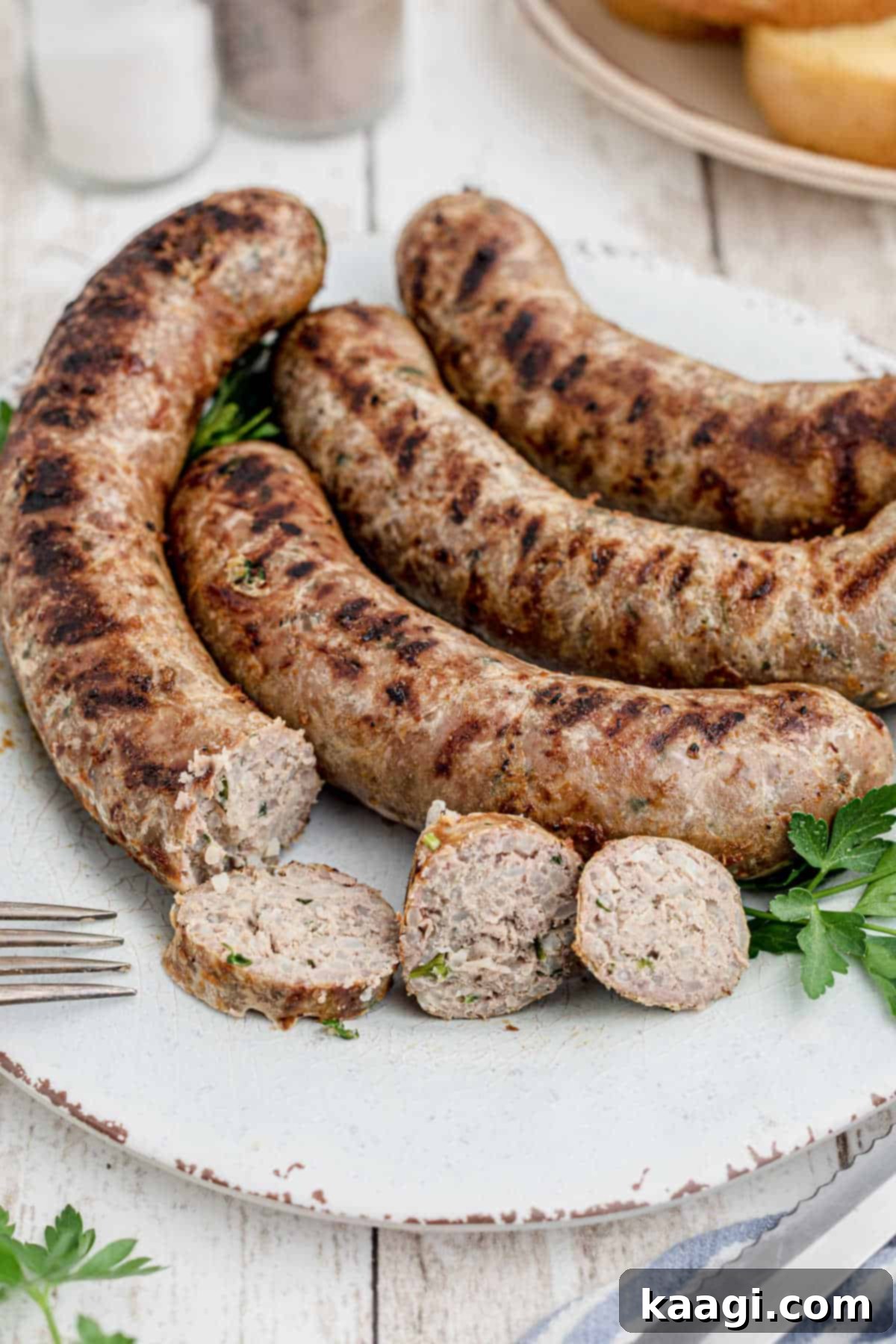 Crafting Authentic Boudin at Home 12 homemade boudin sausage on a plate with a few slices made out of one of them, showing the flavorful interior