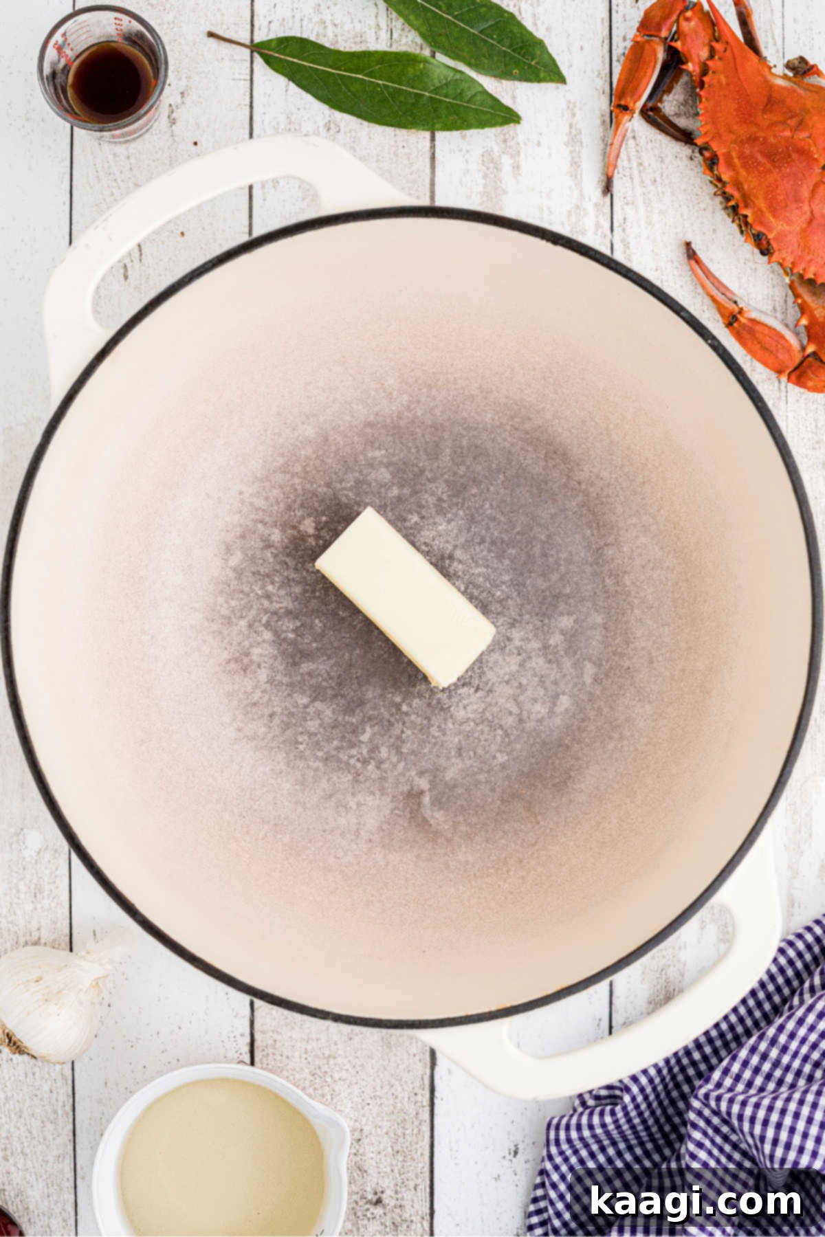 A large Dutch oven with a stick of butter in it.