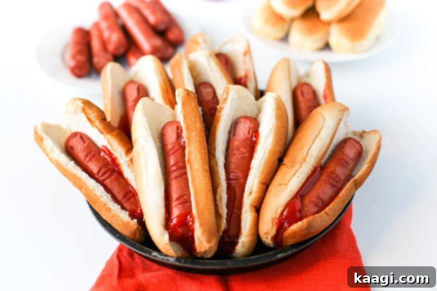 Ghoulish Bloody Finger Hot Dogs for Halloween, made by scoring hot dogs to resemble knuckles and fingertips, then slathered with ketchup to mimic fresh blood for a spooky party food.