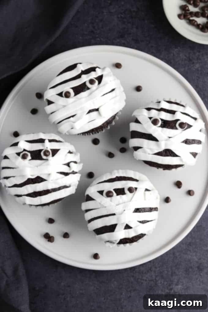 Vegan mummy cupcakes decorated with buttercream and chocolate chip eyes.