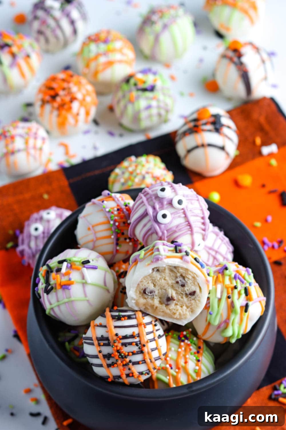 Halloween themed cookie dough balls decorated with candy eyes.