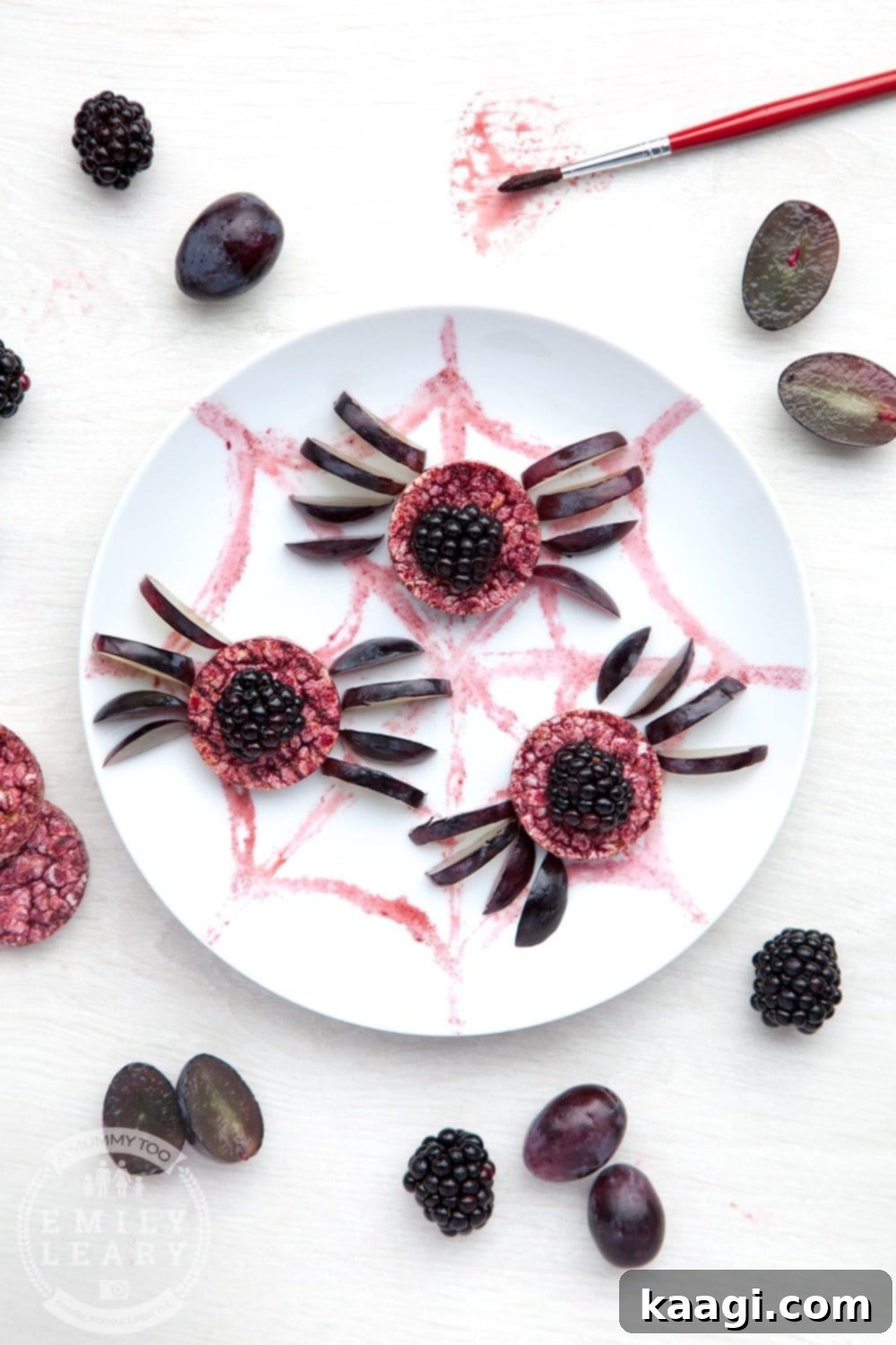 Halloween Rice Cakes decorated with blackberries and grapes as spiders.