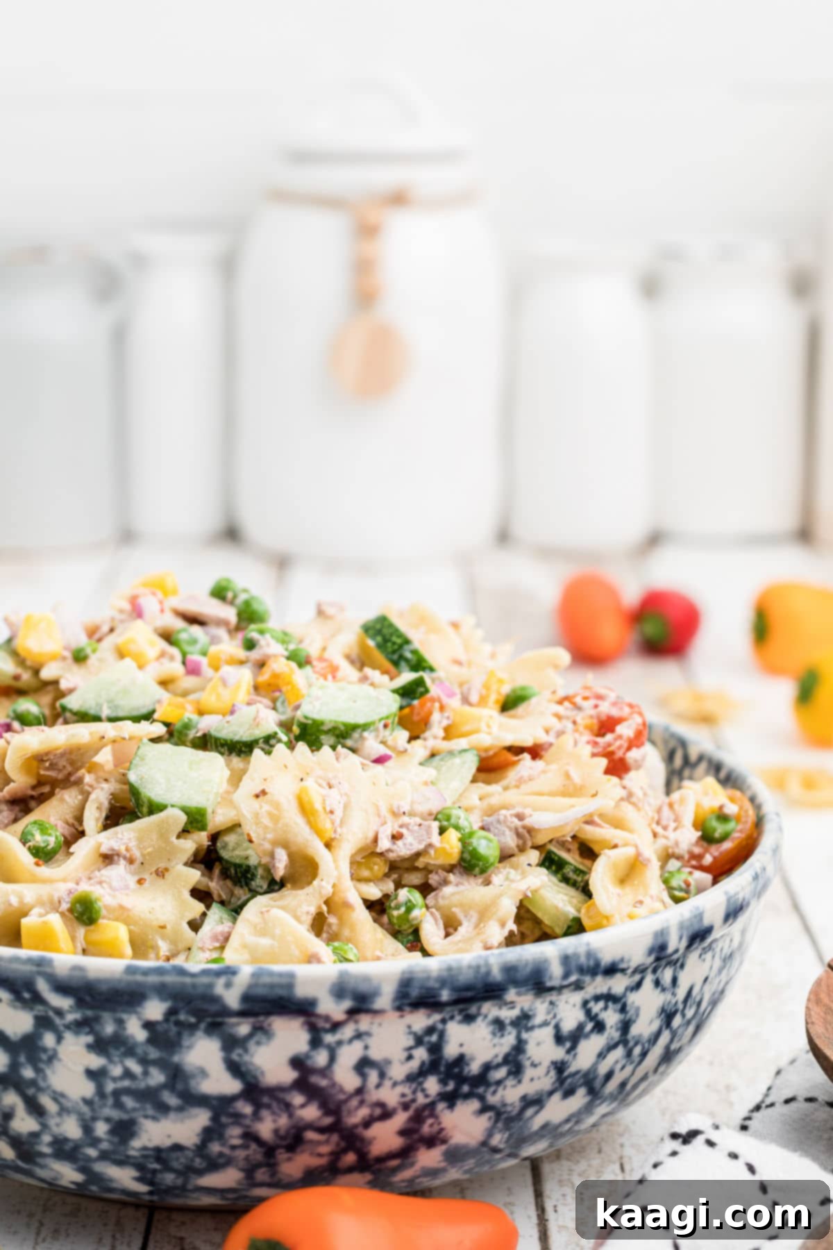 Creamy Tuna Pasta Salad 7 side view of a bowl of creamy tuna pasta salad garnished with fresh herbs