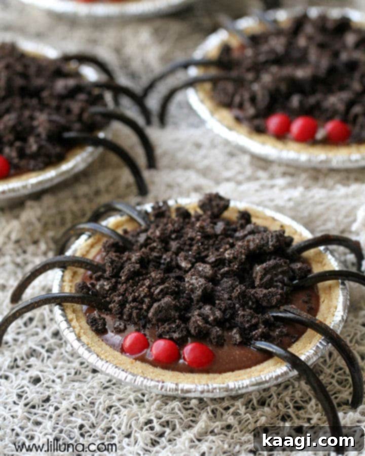 Miniature chocolate puddings creatively decorated to resemble spiders, complete with edible legs and red eyes.