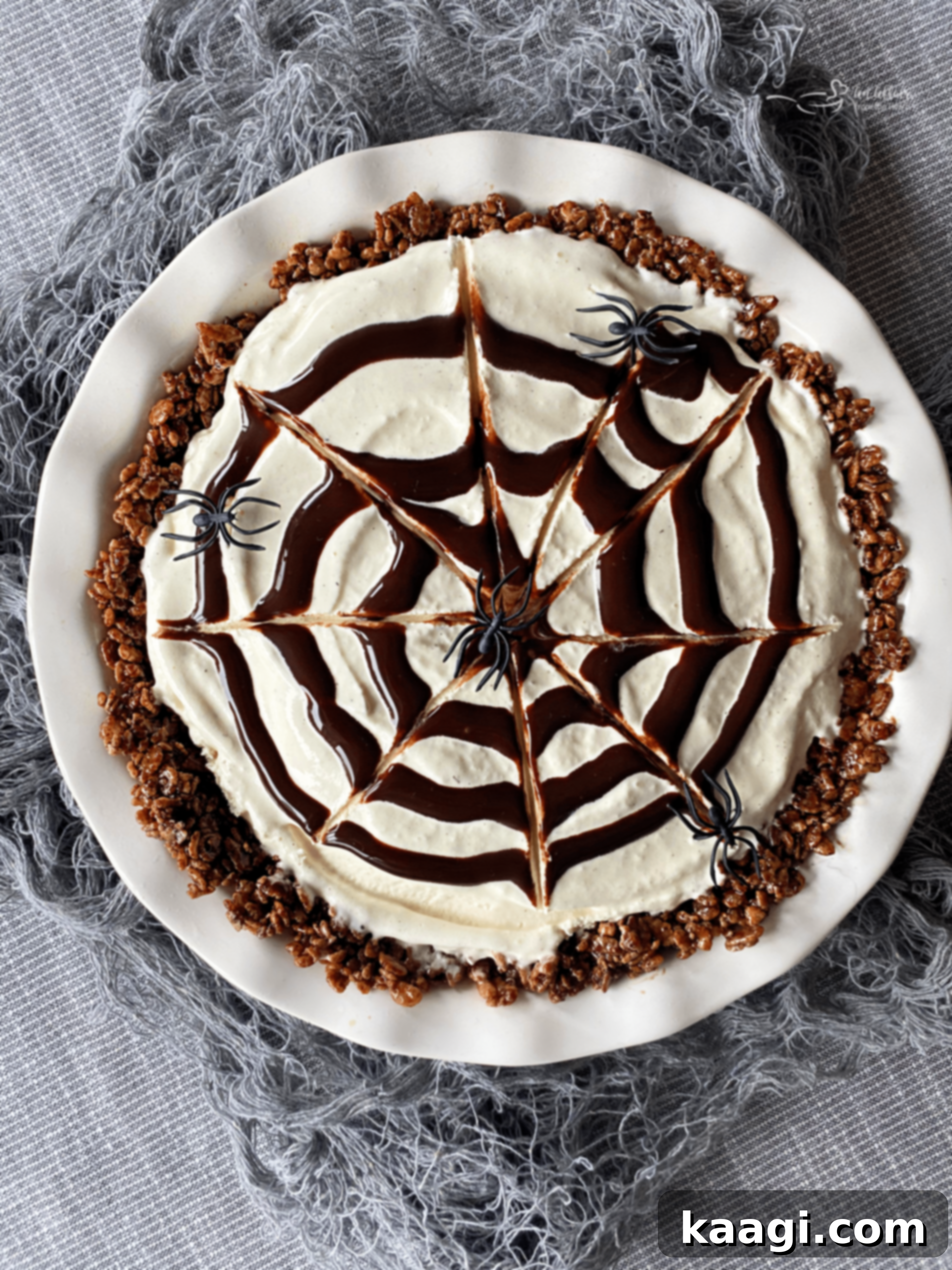 A decadent ice cream pie adorned with a delicate spiderweb decoration on top, perfect for Halloween.