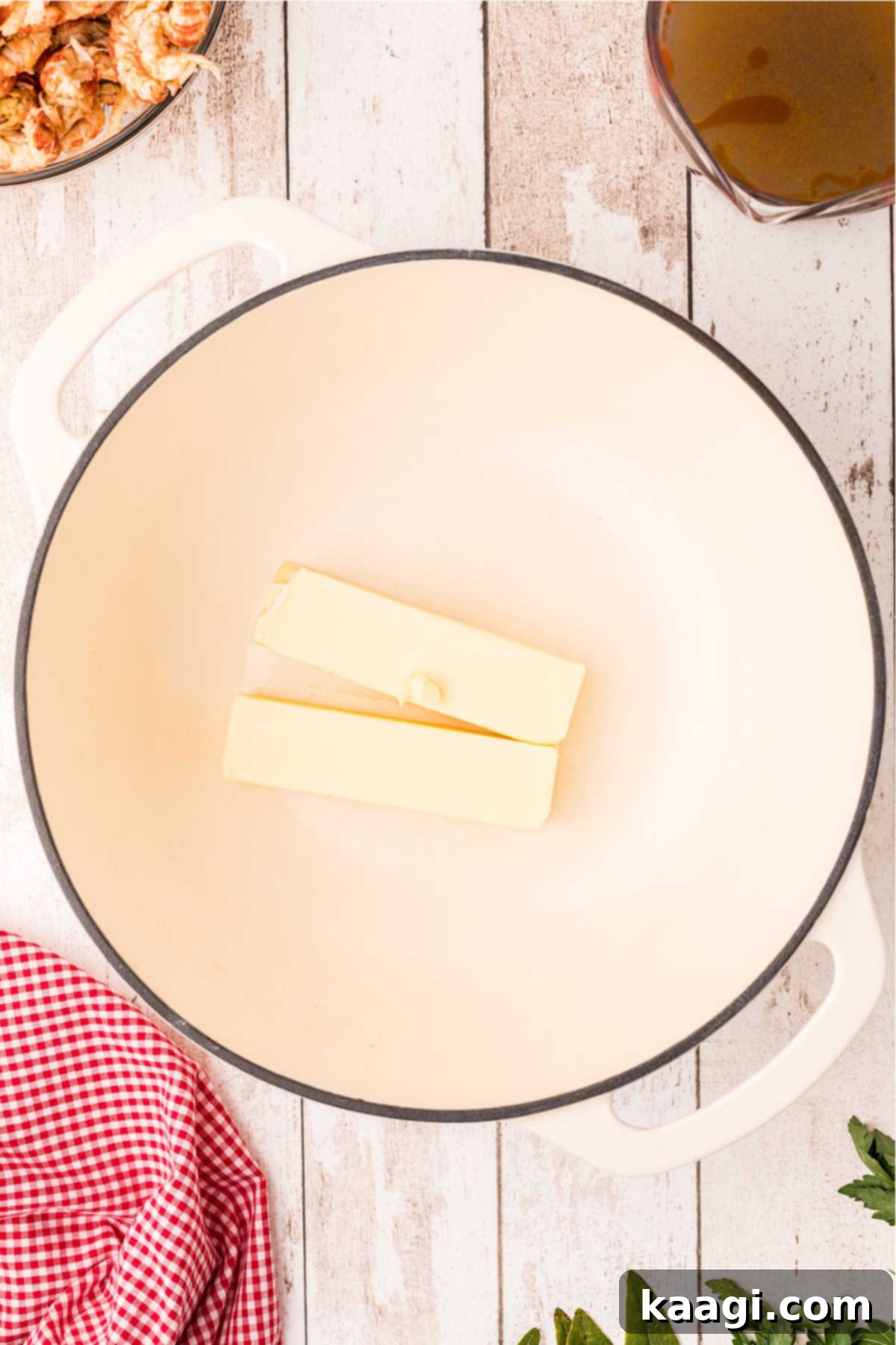 An overhead view of a large Dutch Oven with some butter.