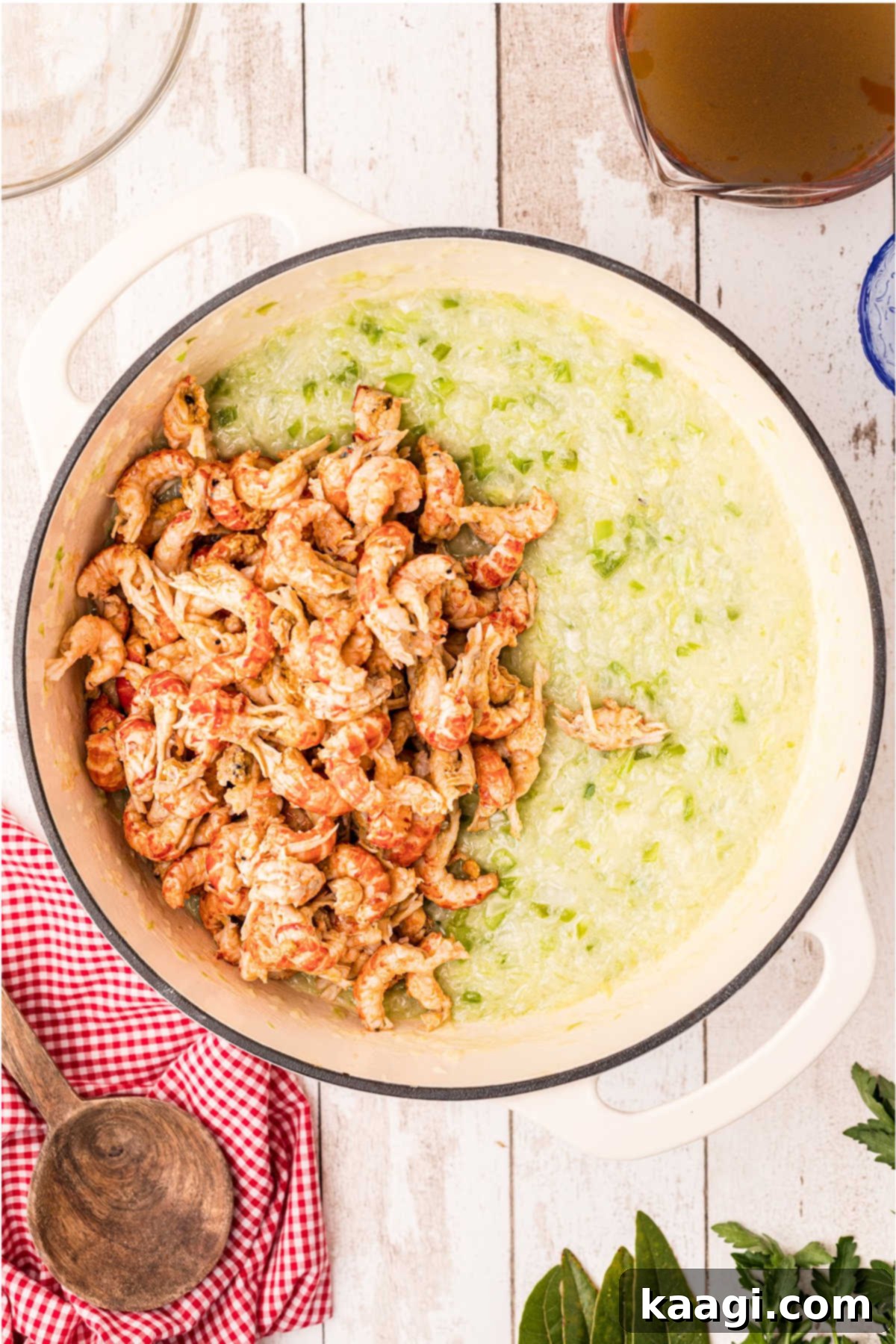 Crawfish tails added to a large Dutch oven full of other ingredients.
