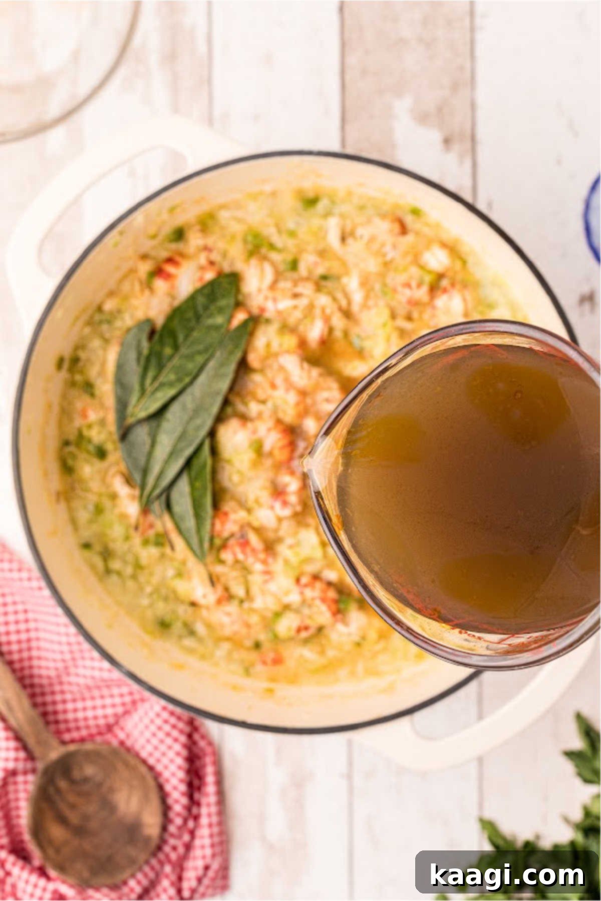 Crawfish stock being poured into a Dutch oven.