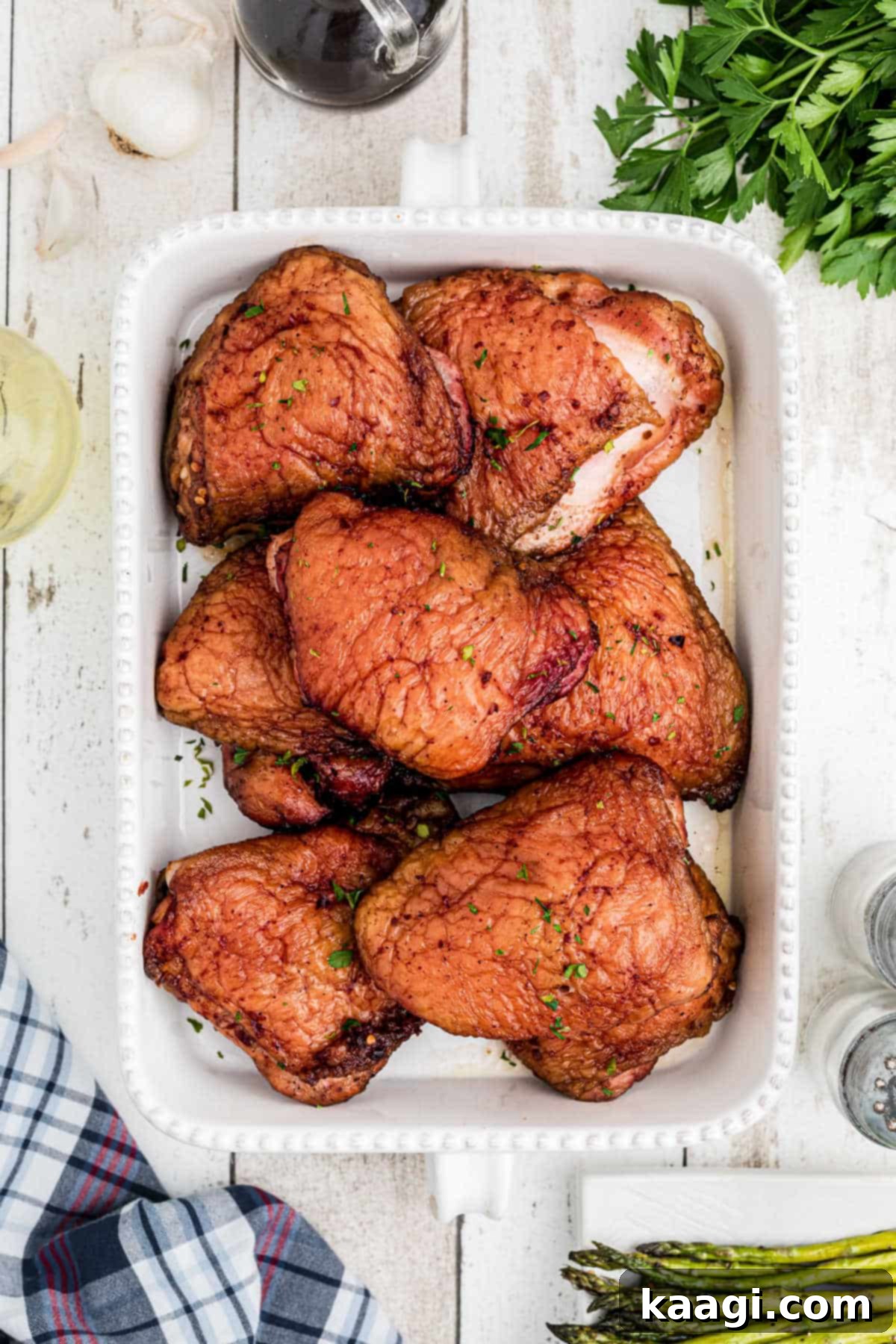 A beautifully plated dish full of golden-brown smoked chicken thighs, garnished with fresh herbs and ready to be enjoyed.