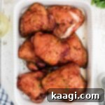 A dish full of golden-brown smoked chicken thighs, ready to be served and enjoyed.