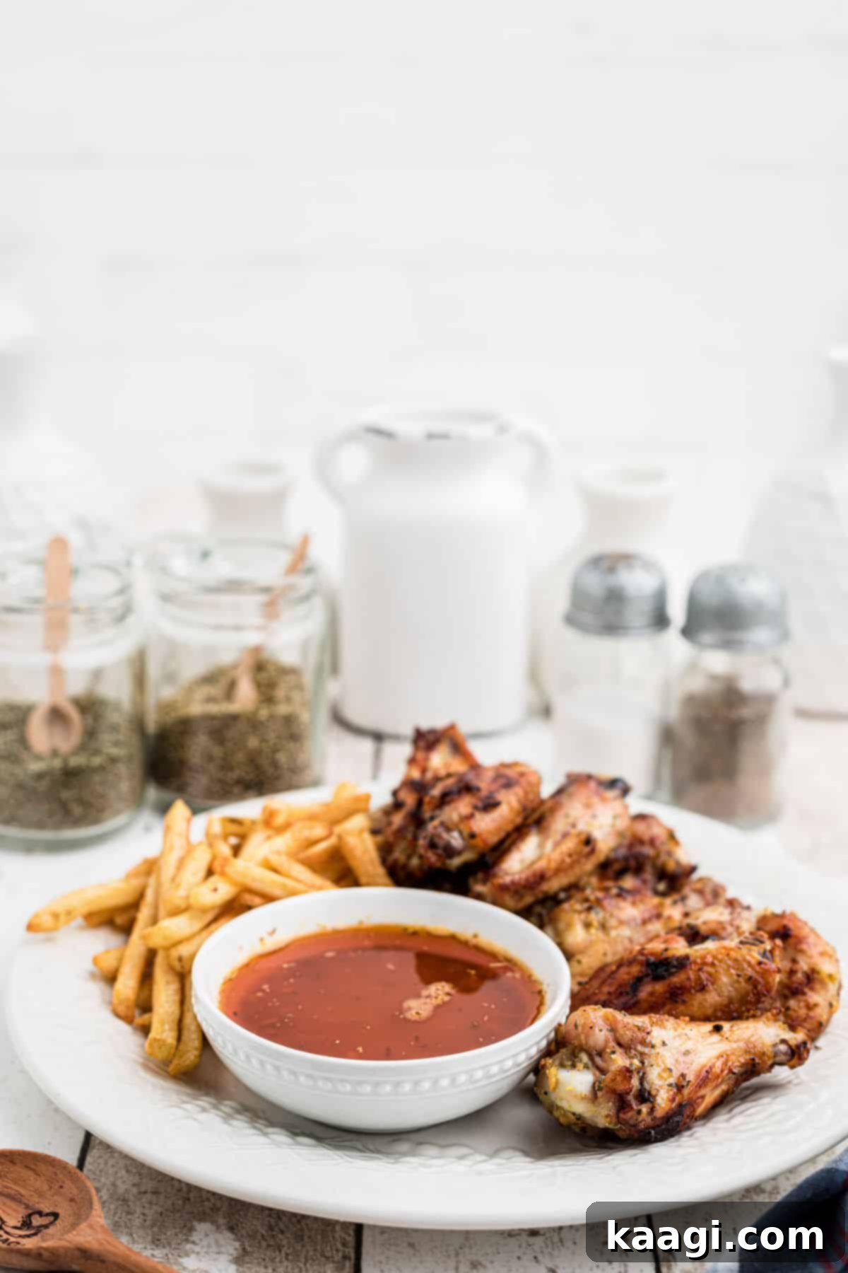 Bold Cajun Butter Glaze 4 side view of a plate of chicken wings with french fries and cajun butter sauce.