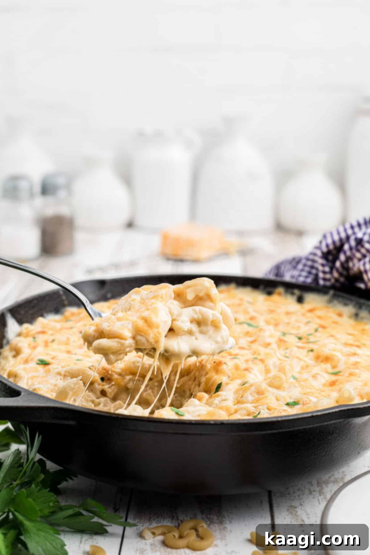 a cast iron skillet full of mac and cheese with a spoon taking some out.