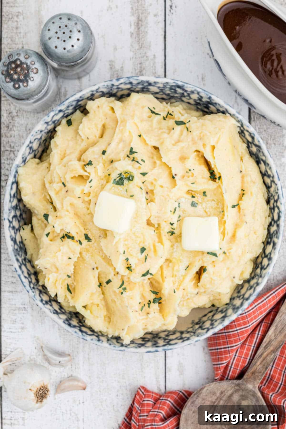 An overhead view of a large bowl of homemade copycat Popeyes mashed potatoes with a dollop of melted butter on top.