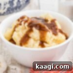 A bowl full of creamy mashed potatoes with rich brown gravy on top, ready to be served.