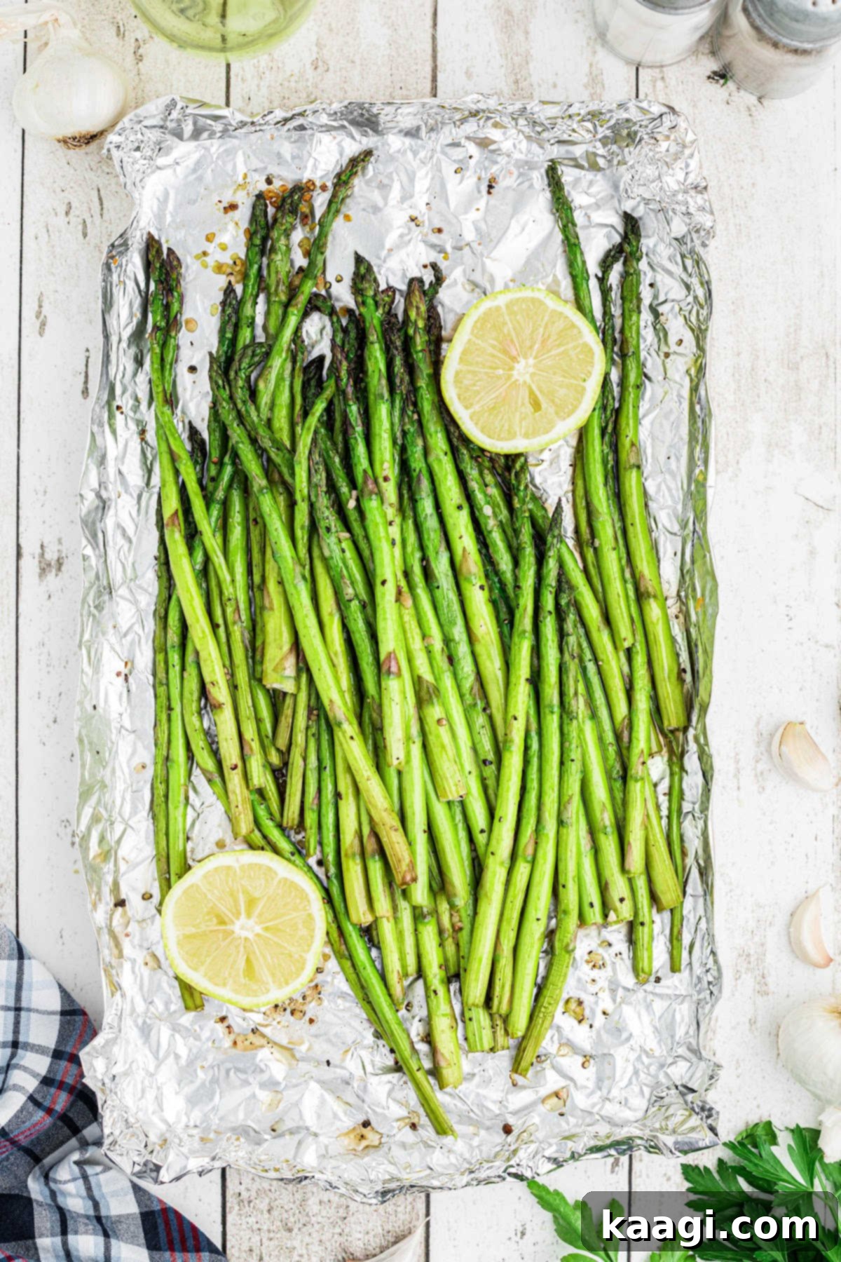 Overhead close-up of beautifully smoked asparagus spears garnished with fresh lemon wedges on the side, ready to be served.