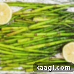 Overhead close-up of some smoked asparagus with some lemon on the sides, illustrating the final dish.